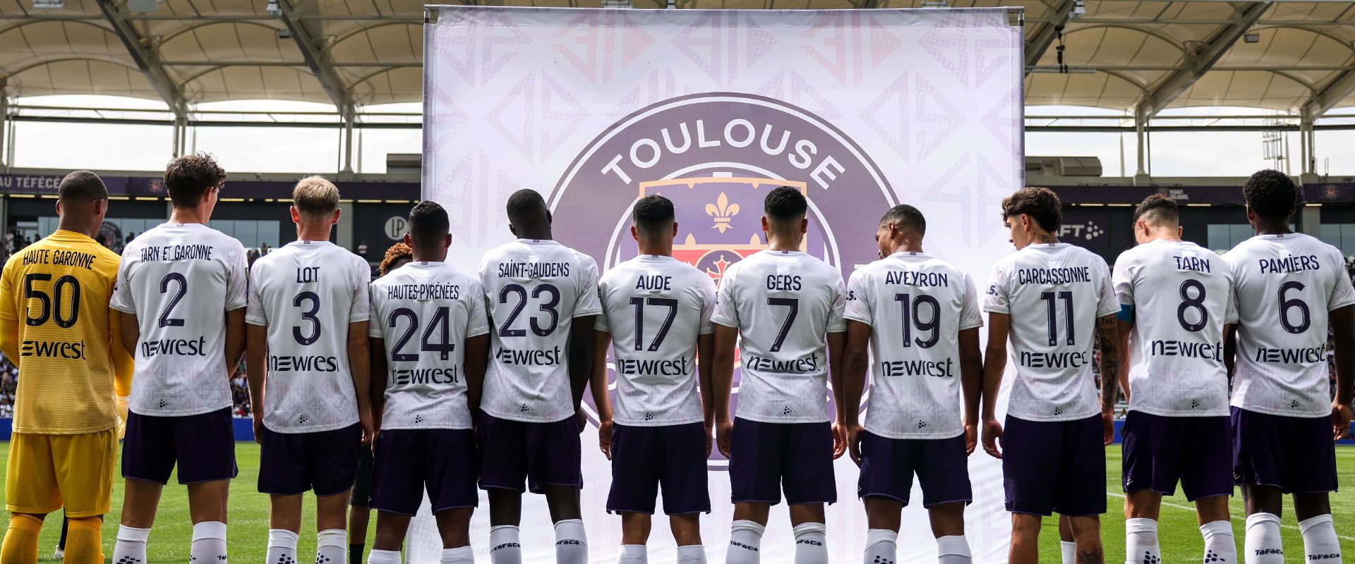 Bandeau - joueurs de dos avec les maillot floqués aux noms de villes et départements- Le maillot Heard - Toulouse Football Club